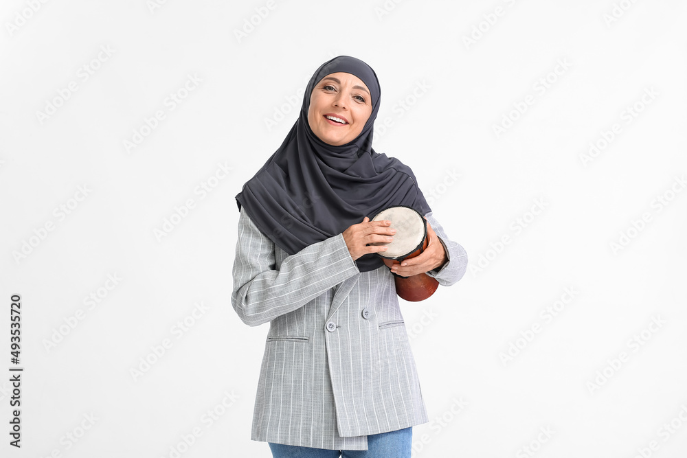 Muslim music teacher with drum on light background Muslim music teacher with drum on light background