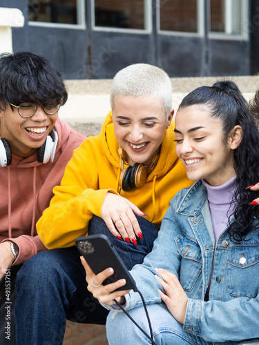 Group of young students looking at smart phone smiling © gonzagon