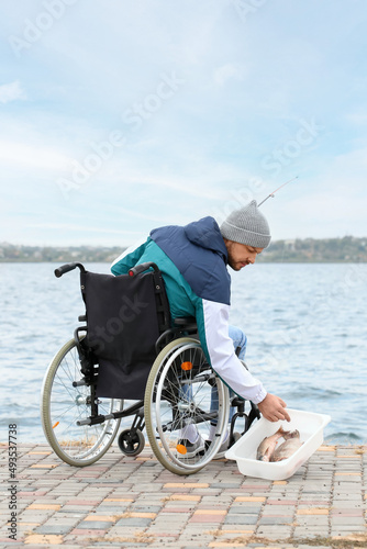 Man in wheelchair fishing o...