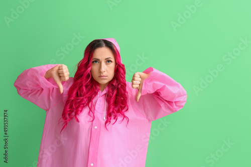 Displeased woman in raincoa...