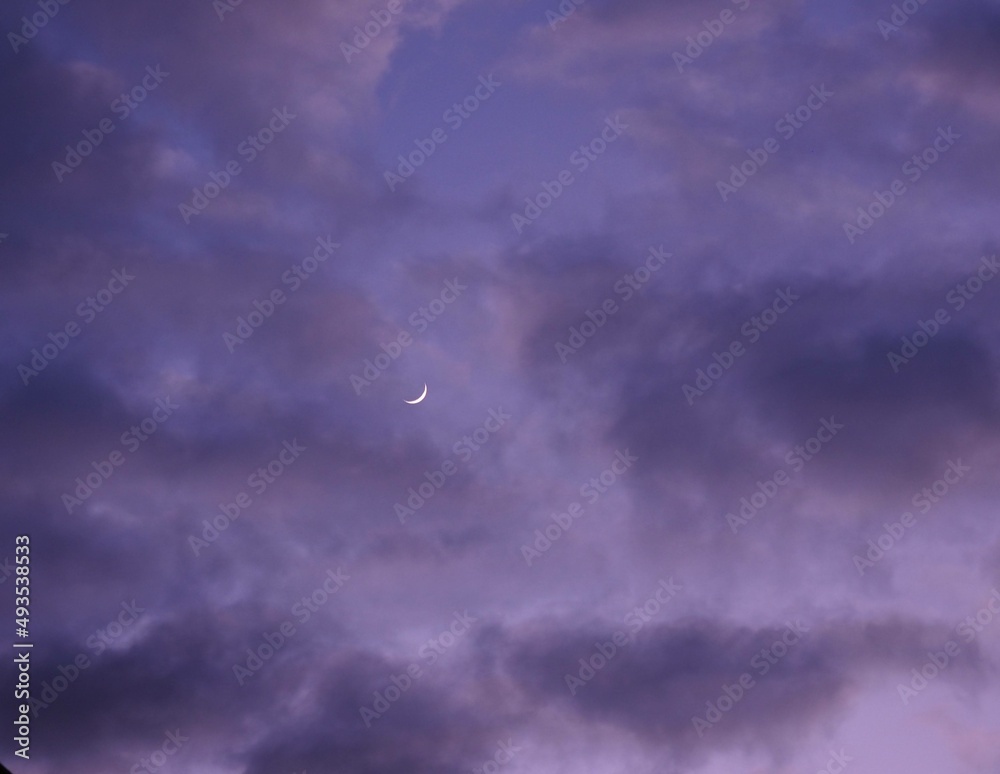 Obraz premium Crescent moon and clouds at dusk