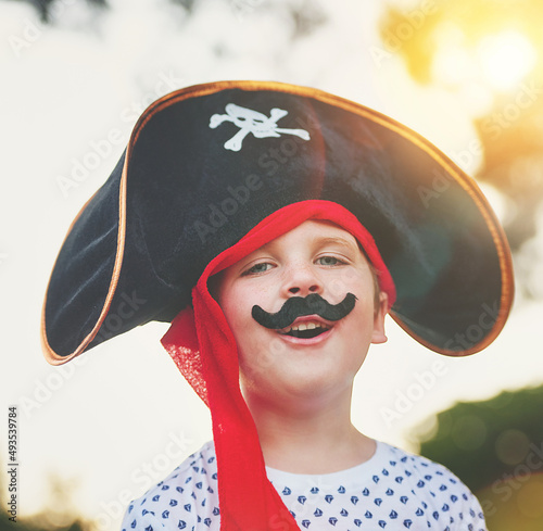 Yo ho, yo ho, a pirates life for me. Portrait of a cute little boy posing outside while dressed up like a pirate. photo