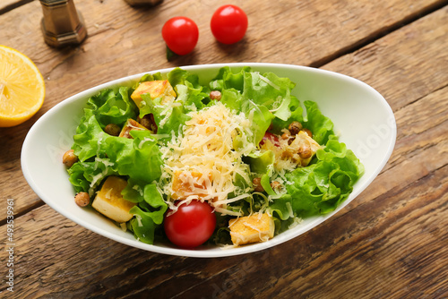 Bowl with tasty vegan Caesar salad on wooden background, closeup