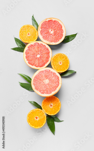 Fresh orange and grapefruit slices on light background