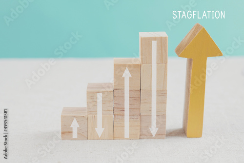 arrows up and down on wooden blocks ladder, Rising and inclining arrows, financial crisis, Stagflation concept photo