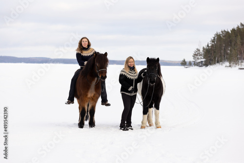 Two Icenlandic horses and two riders on the lake ice in Finland.