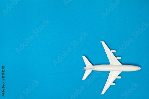 Airplane model. White plane on blue background. Travel vacation concept. Summer background. Flat lay.