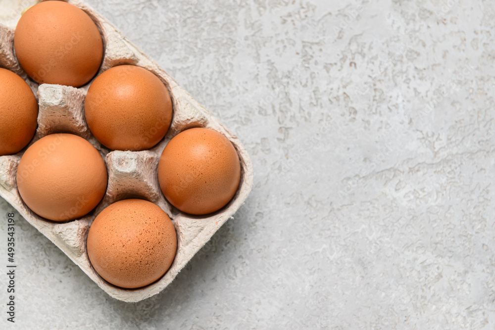 Holder with fresh chicken eggs on grey background, closeup Holder with fresh chicken eggs on grey background, closeup