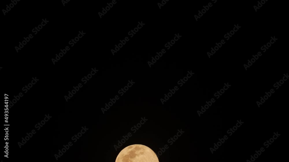 Full moon moving through the dark night sky Full moon moving through the dark night sky