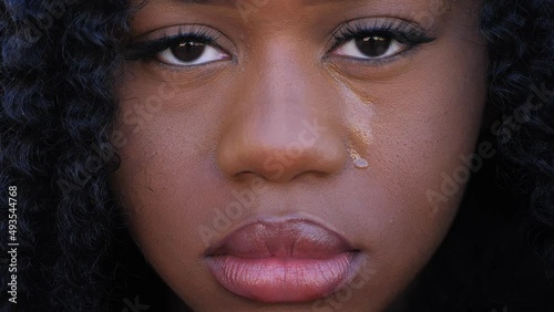 Sad african-american woman crying: upset depressed black teenager crying alone at home