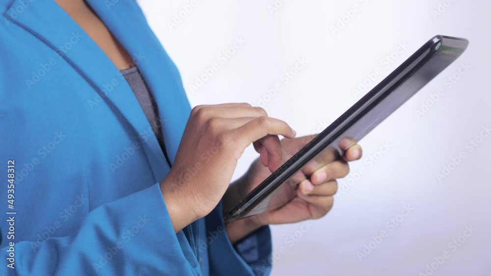 Close up of black woman hands using tablet pc: Woman sitting and using tablet: Female hands holding a tablet Close up of black woman hands using tablet pc: Woman sitting and using tablet: Female hands holding a tablet