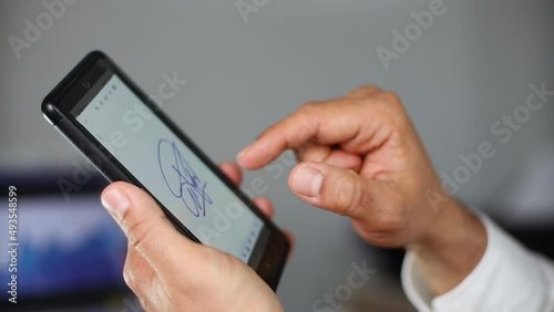 Man signing contract on smartphone with electronic signature