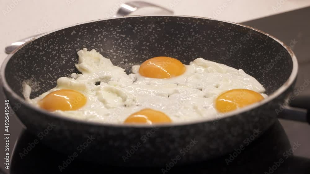 Cooking scrambled eggs on skillet. Woman stirring eggs on skillet to prepare scrambled eggs for breakfast. Cooking process. High quality 4k footage Cooking scrambled eggs on skillet. Woman stirring eggs on skillet to prepare scrambled eggs for breakfast. Cooking process. High quality 4k footage