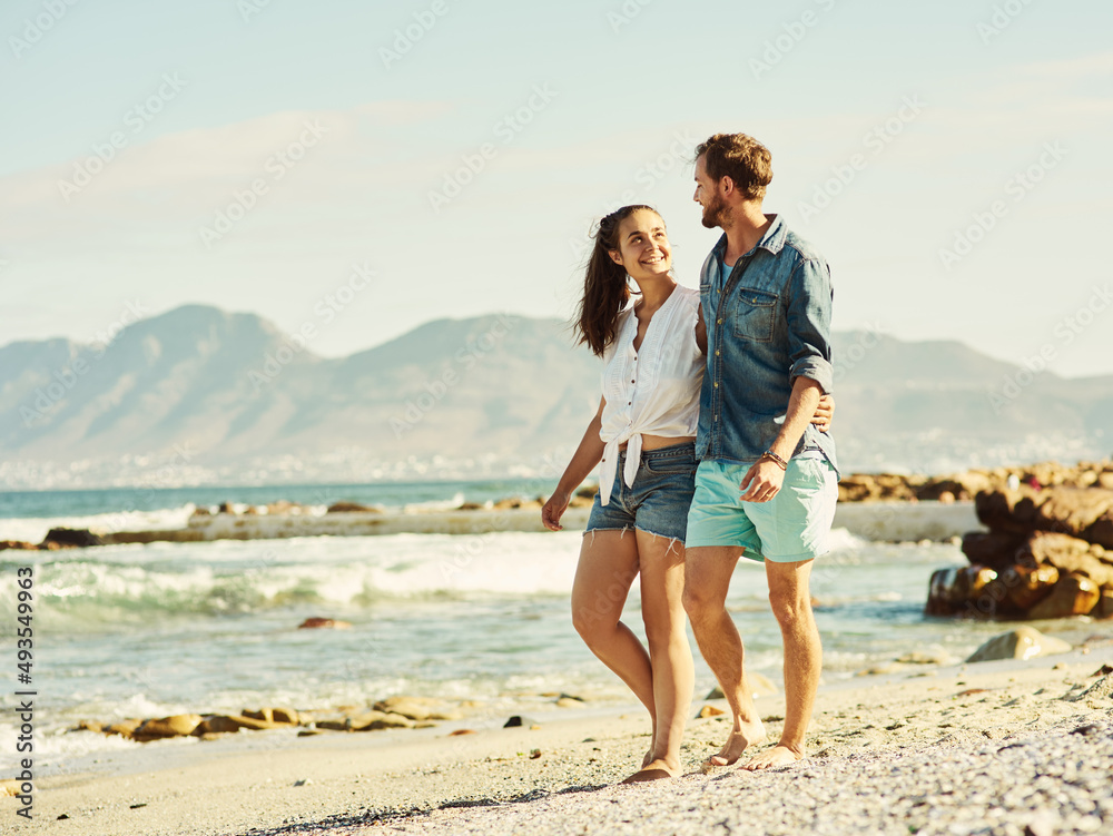 We share a deep love for the beach. Shot of a young married couple walking on the beach. We share a deep love for the beach. Shot of a young married couple walking on the beach.