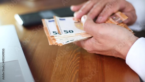 Man counting euro banknotes sitting at the table