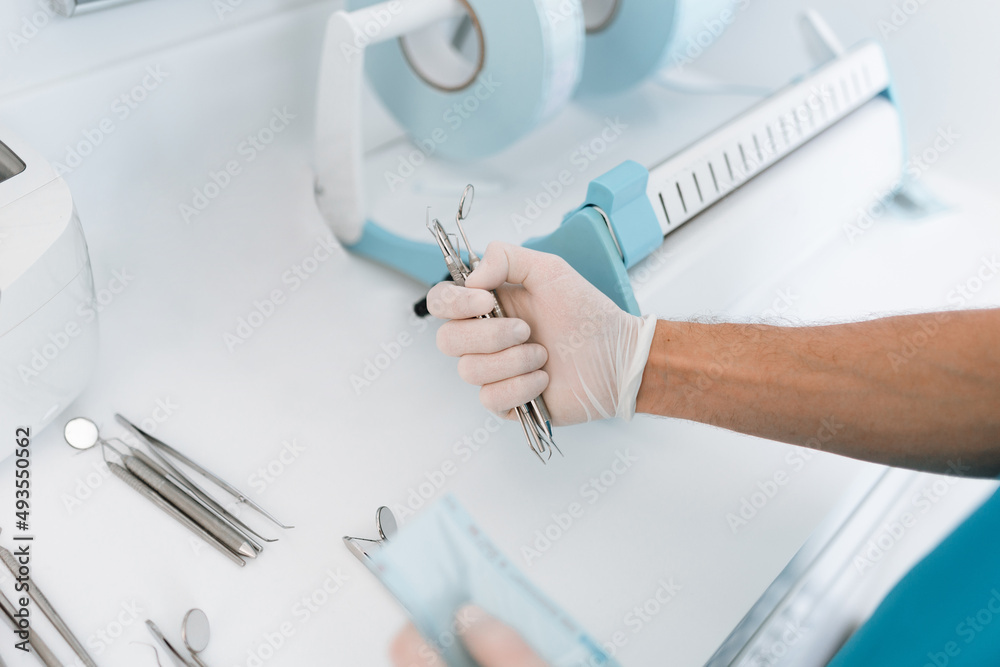 Dentist assistant sterilizing and packing dentist equipment in plastic