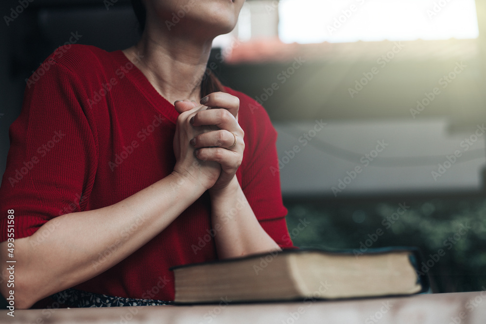Asian woman praying while holding bible and believe in God.