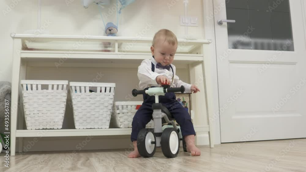 Kid on baby bicycle balance bike for toddlers with colorful balloons, 1 year old baby boy celebrating his first birthday at home. High quality 4k footage Kid on baby bicycle balance bike for toddlers with colorful balloons, 1 year old baby boy celebrating his first birthday at home. High quality 4k footage