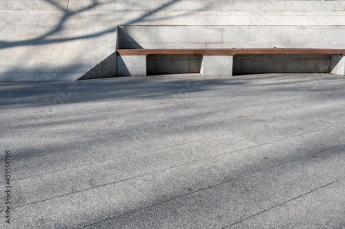 The sun shone on a wooden stool in the empty slate square