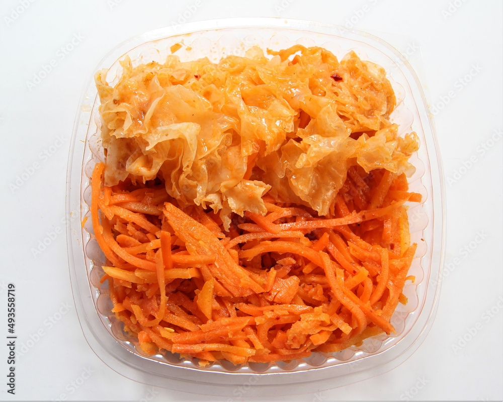 Salad Scallop from carrots and scallop. Salad in a disposable bowl. Salad Scallop from carrots and scallop. Salad in a disposable bowl.