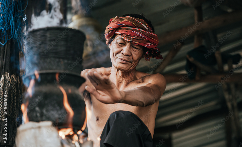 Senior man steaming sticky rice with wood stove lifestyle in countryside