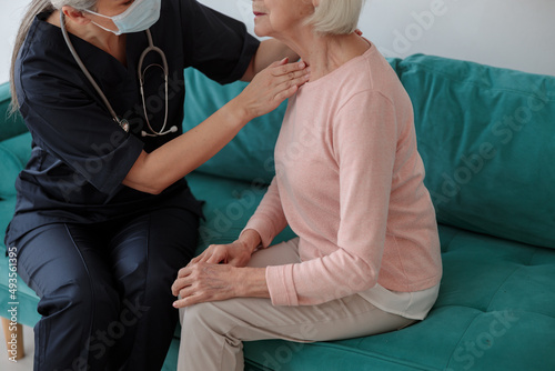 Medical worker touching a neck of an elderly woman © Kostiantyn