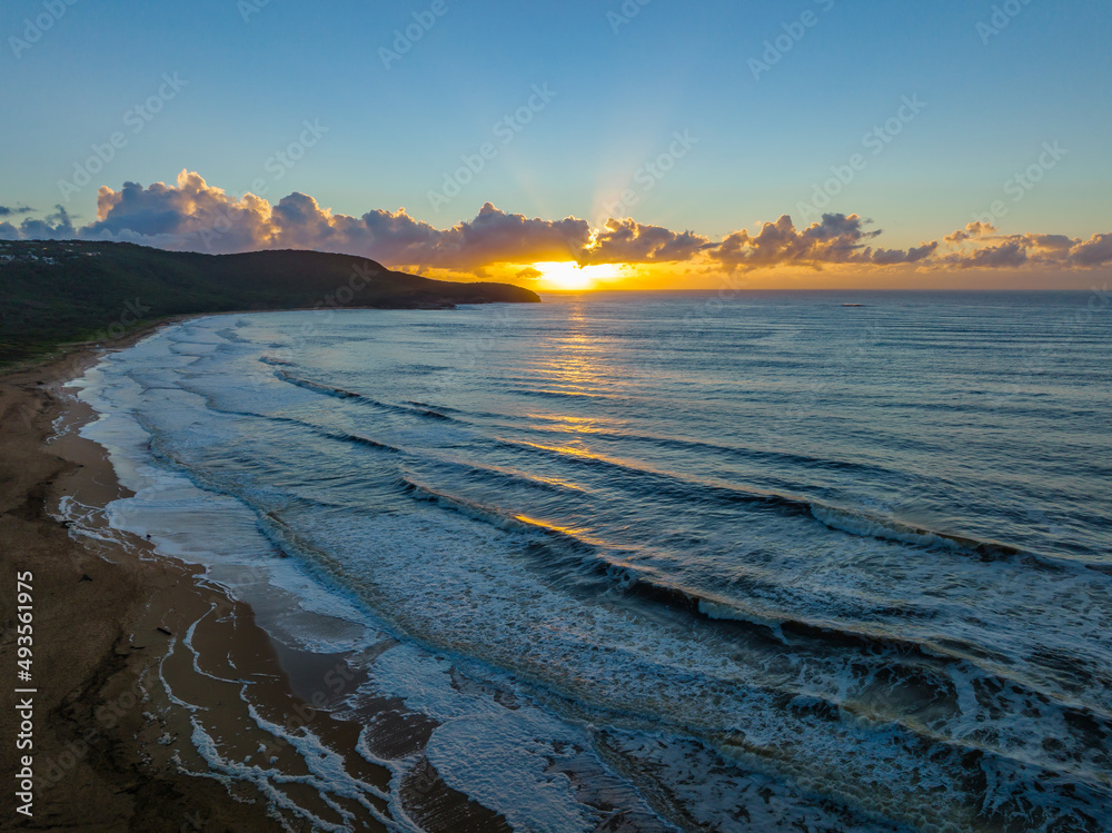 Aerial sunrise seascape with sea foam and low cloud bank