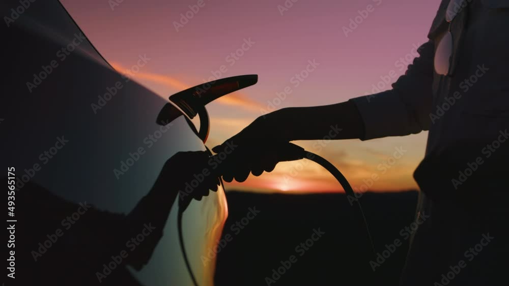 Scenic pink sunset with golden clouds above zero emission modern electric car 6K