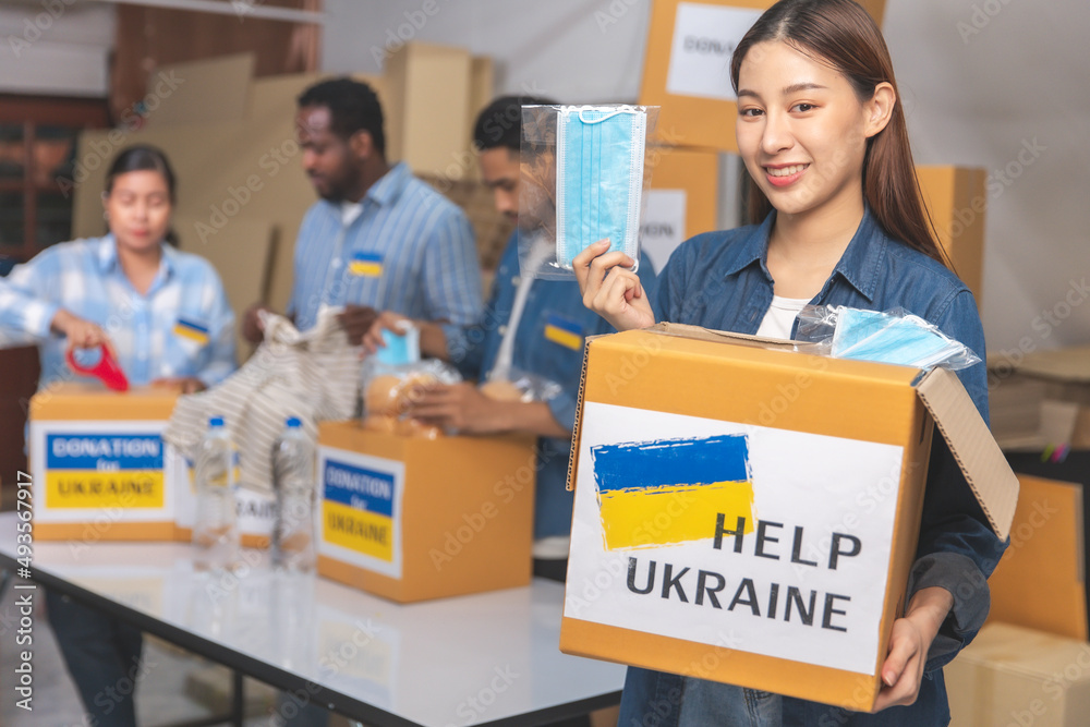 Group of volunteers African ,asian man and asian woman preparing food donations for people in need in Ukrain., Humanitarian aid concept. Group of volunteers African ,asian man and asian woman preparing food donations for people in need in Ukrain., Humanitarian aid concept.