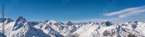 Panoramic view of winter snowy mountains in Caucasus region in Russia with blue sky © SDF_QWE