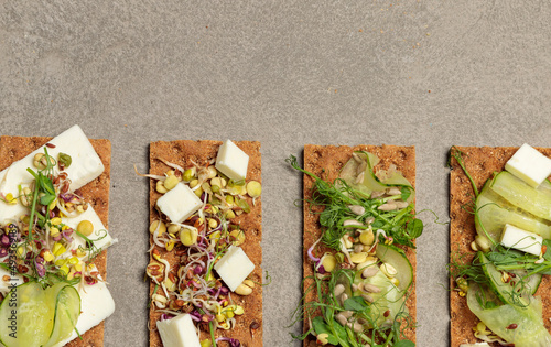 Finn crisp with sprouts, microgreens, cucumber, feta and seeds. Vegan snack. Close-up, top view, copy of the space photo