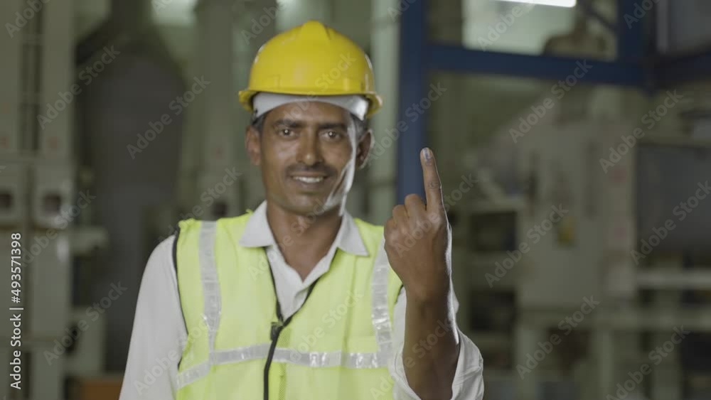 Handheld shot of industrial worker showing Ink marked finger after voting at electionby looking at camera - concept of responsibility, freedom and democracy. Handheld shot of industrial worker showing Ink marked finger after voting at electionby looking at camera - concept of responsibility, freedom and democracy.
