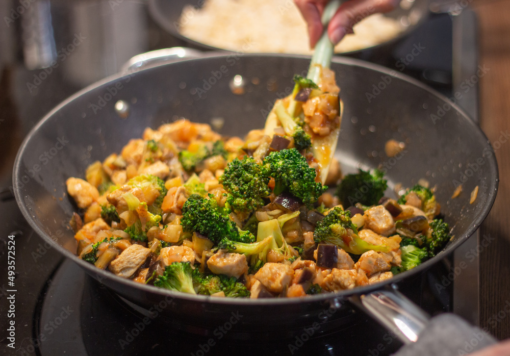 A delicious Chinese dish is fried chicken with broccoli in a wok. The process of cooking chicken with broccoli vegetables in a steel pan. Teriyaki chicken and broccoli in a cast-iron pan. A delicious Chinese dish is fried chicken with broccoli in a wok. The process of cooking chicken with broccoli vegetables in a steel pan. Teriyaki chicken and broccoli in a cast-iron pan.