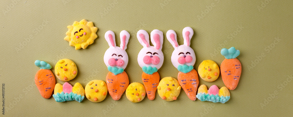 Happy Easter concept. Preparation for holiday. Easter marshmallow candy chiken, rabbit, carrot, bunny on green pastel background. Simple cute, funny minimalism flat lay top view, copyspace banner