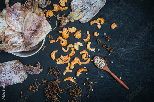 Dried seafood With dried squid and dried shrimp on a black wooden table