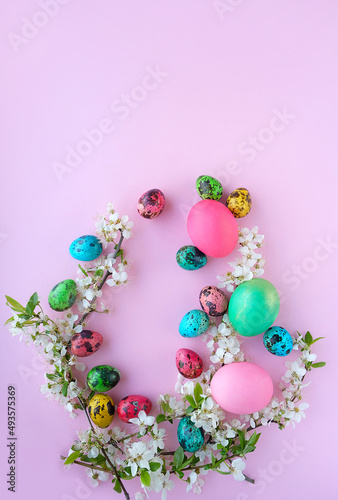Easter colorful eggs and cherry flowers on pink background. symbol of Easter Christian holiday. spring festive decor. flat lay