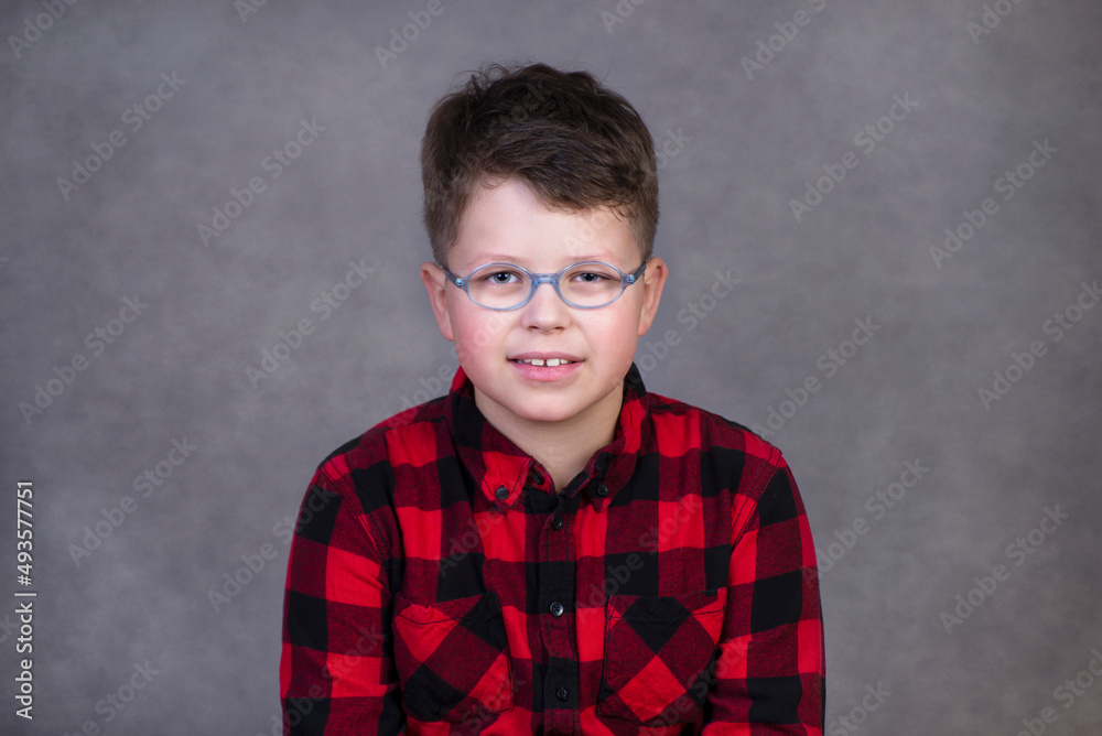 Portrait of little boy looking at camera on a gray background in the studio Portrait of little boy looking at camera on a gray background in the studio