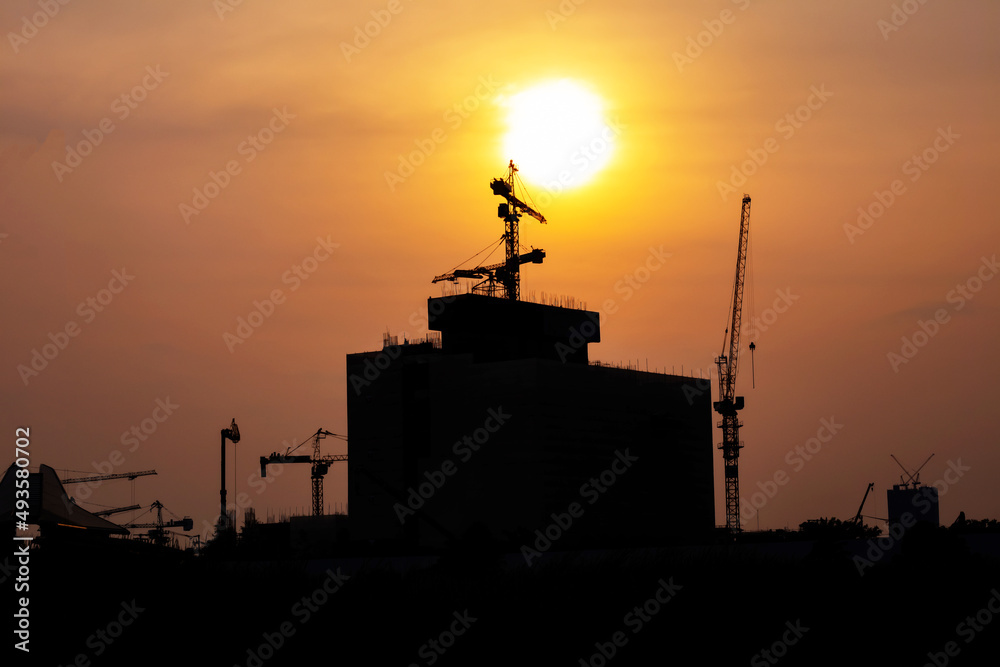 those tower cranes were used to create built and in the picture, there was a construction site with sunset.