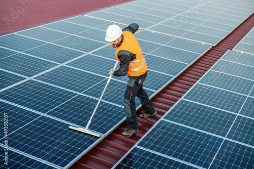 A neat handyman cleaning solar panels.