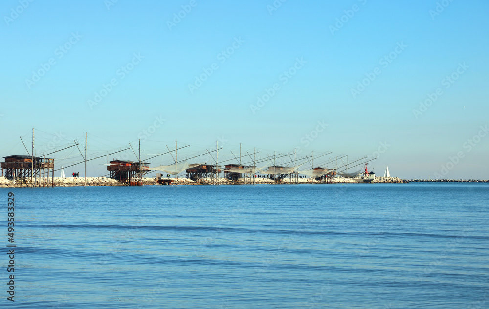 fishing huts on the dike and large nets for catching fish and crustaceans in the Adriatic sea in Italy