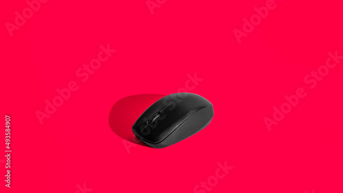 Isolated computer mouse on red background with hard shadow. 