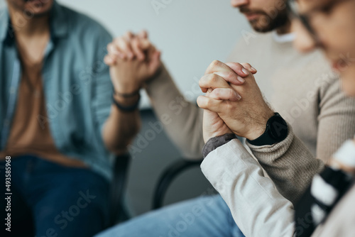 Close up of people holding hands and supporting each other during group therapy session.
