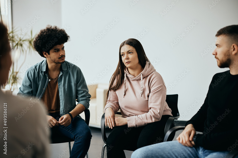 Young woman shares her problems with attenders of group therapy at community center. Young woman shares her problems with attenders of group therapy at community center.