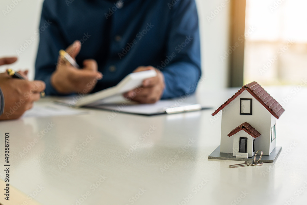 Fototapeta premium Real estate agents hold homes offered to clients after signing contracts. Real estate ideas, moving house, or renting out real estate in the office.