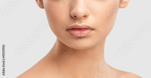 Lips and face of a young woman close-up. Cosmetic care for face and lips.
