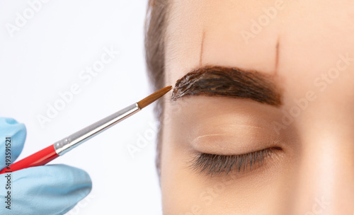 Make-up artist makes markings for eyebrow and paints eyebrows. Professional makeup and facial care.