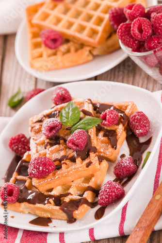 Waffles with raspberries and chocolate cream.