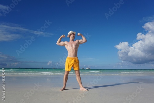 Sexual man with strong body on Boracay beach. Athletic guy training on beach.