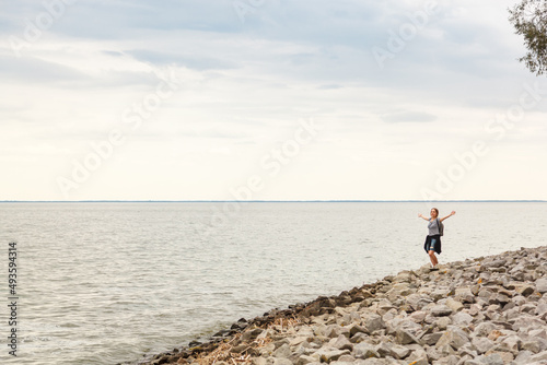 Beautiful girl on the sea with blue sky and clouds