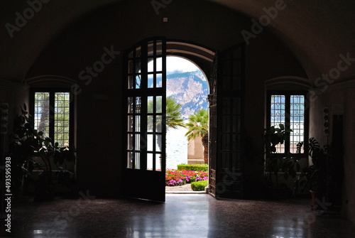 View of Garden Through Open Arched Door from Dark Interior Room